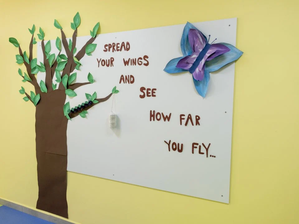 “Spread your wings and see how far you fly” yazılı sınıf panosu